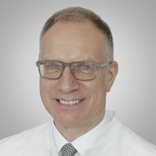 Dr. med. Thomas Kijak, Facharzt für Chirurgie, Team AVC Siloah St. Trudpert Klinikum, Portraitfoto vor Hintergrund mit Grauverlauf